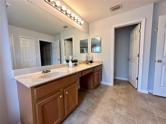 2820 Pankaw Ln, Valrico, FL 33596 - bathroom with a textured ceiling, double vanity, and baseboards