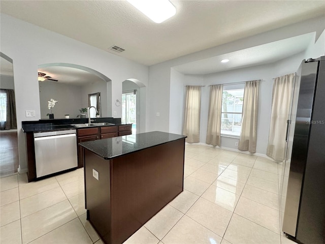 2820 Pankaw Ln, Valrico, FL 33596 - kitchen featuring appliances with stainless steel finishes, a sink, arched walkways, plenty of natural light, and a textured ceiling