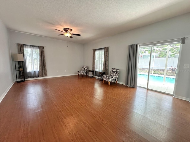 2820 Pankaw Ln, Valrico, FL 33596 - unfurnished living room featuring dark wood-style floors, a ceiling fan, plenty of natural light, and a textured ceiling
