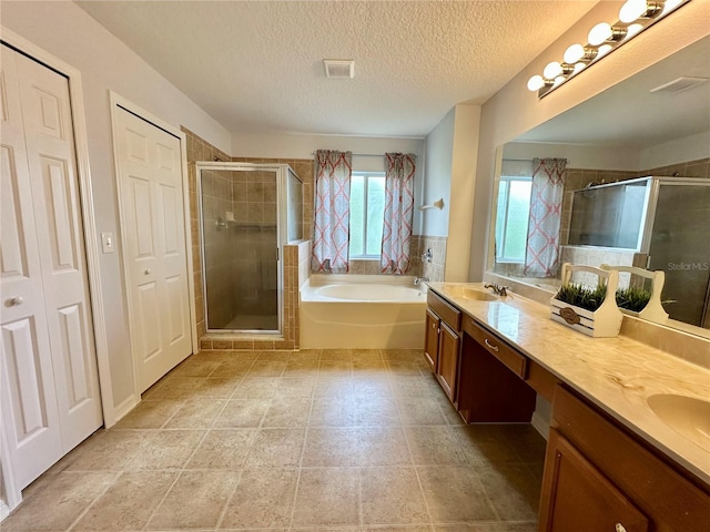 2820 Pankaw Ln, Valrico, FL 33596 - bathroom featuring a stall shower, a bath, double vanity, and a textured ceiling
