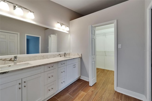 1601 Westerly Dr, Brandon, FL 33511 - bathroom featuring double vanity, baseboards, a sink, and wood finished floors