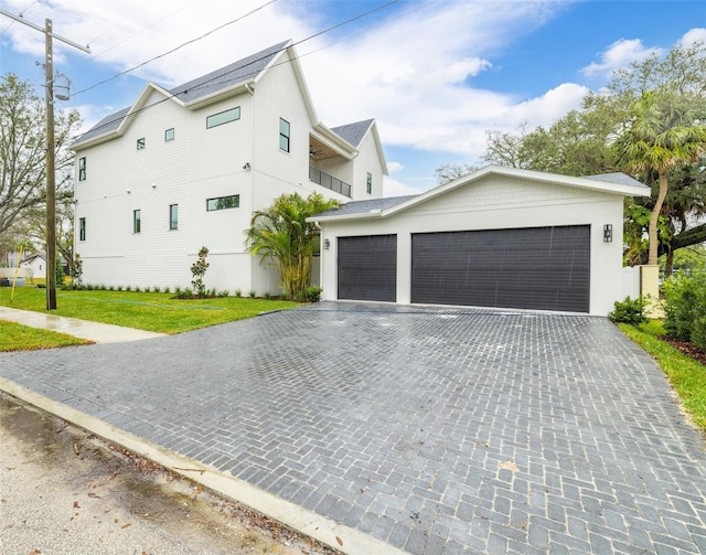 2218 S Occident St, Tampa, FL 33629 - view of side of property featuring a yard, decorative driveway, a garage, and stucco siding