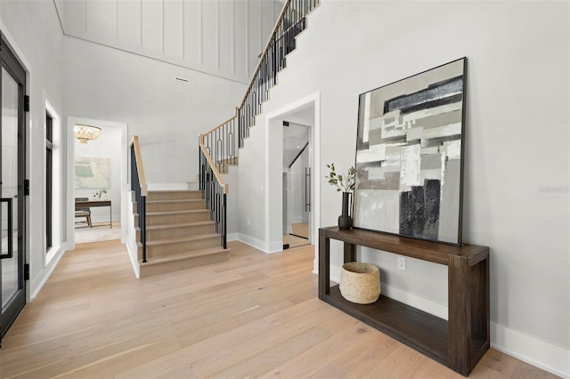 2218 S Occident St, Tampa, FL 33629 - foyer featuring a high ceiling, a notable chandelier, baseboards, light wood-type flooring, and stairway