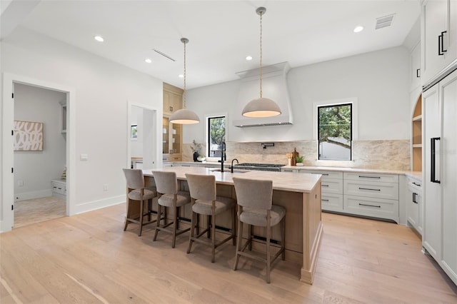 2218 S Occident St, Tampa, FL 33629 - kitchen featuring open shelves, a kitchen island with sink, premium range hood, recessed lighting, and tasteful backsplash