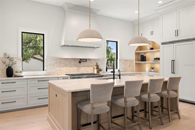 2218 S Occident St, Tampa, FL 33629 - kitchen featuring plenty of natural light, paneled fridge, light wood finished floors, and a center island with sink