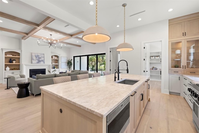 2218 S Occident St, Tampa, FL 33629 - kitchen with beamed ceiling, built in shelves, a sink, light wood-style flooring, and appliances with stainless steel finishes