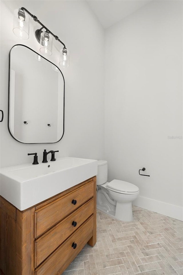 2218 S Occident St, Tampa, FL 33629 - half bathroom featuring toilet, baseboards, brick floor, and vanity