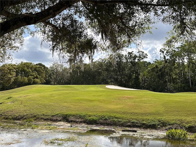 surrounding community featuring a lawn and golf course view