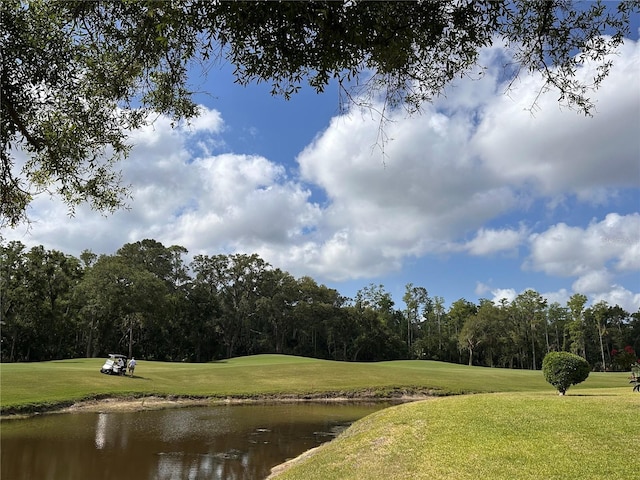 view of home's community featuring a yard, a water view, and view of golf course