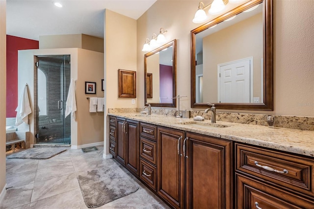 full bathroom featuring double vanity, baseboards, a shower stall, and a sink