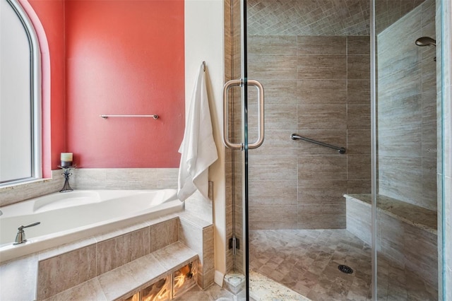 full bathroom featuring a bath and a shower stall