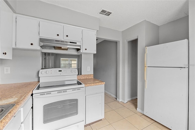 kitchen with white appliances, white cabinetry, light tile patterned floors, under cabinet range hood, and visible vents