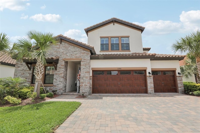 21746 Amelia Rose Way, Land O Lakes, FL 34637 - mediterranean / spanish house with a tile roof, stone siding, a garage, stucco siding, and decorative driveway