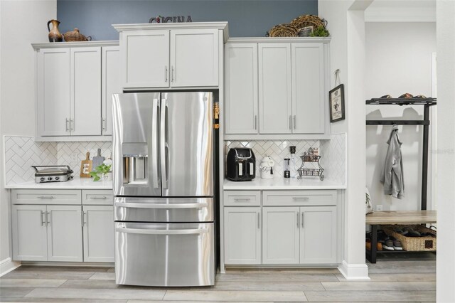 21746 Amelia Rose Way, Land O Lakes, FL 34637 - kitchen featuring light countertops, light wood finished floors, stainless steel fridge with ice dispenser, and tasteful backsplash