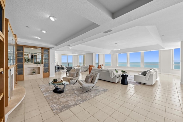 1170 Gulf Blvd Unit 2101, Clearwater Beach, FL 33767 - living area with light tile patterned floors, a water view, a tray ceiling, and a textured ceiling