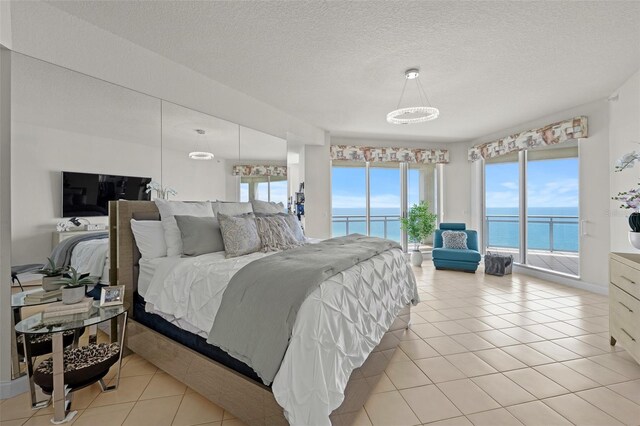 1170 Gulf Blvd Unit 2101, Clearwater Beach, FL 33767 - bedroom with access to exterior, multiple windows, a water view, and a textured ceiling