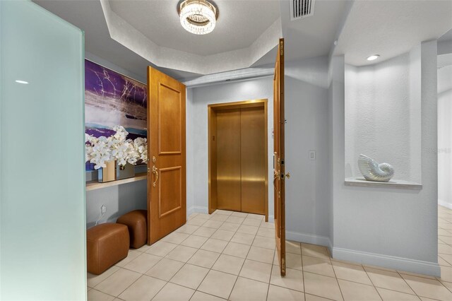 1170 Gulf Blvd Unit 2101, Clearwater Beach, FL 33767 - corridor featuring elevator, tile patterned floors, baseboards, and a raised ceiling