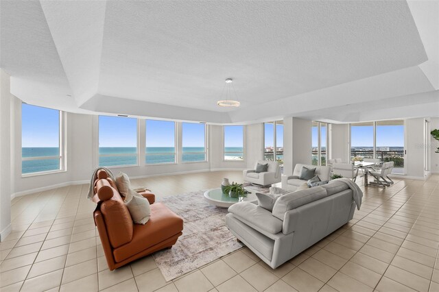 1170 Gulf Blvd Unit 2101, Clearwater Beach, FL 33767 - living room with a tray ceiling, plenty of natural light, light tile patterned flooring, and a textured ceiling