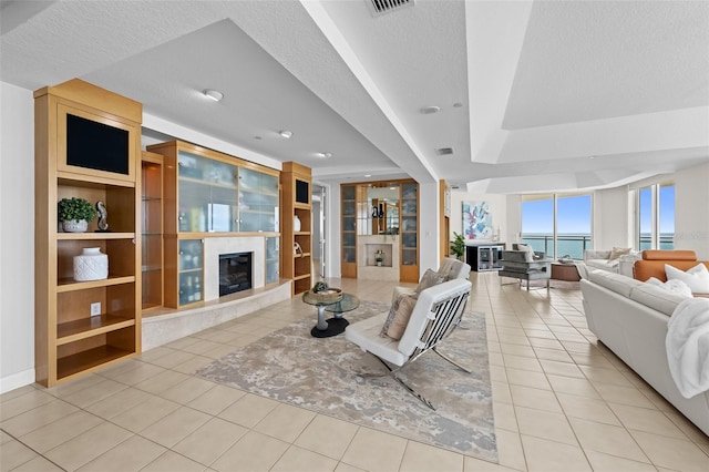 1170 Gulf Blvd Unit 2101, Clearwater Beach, FL 33767 - tiled living room featuring a fireplace, a textured ceiling, built in features, and a tray ceiling