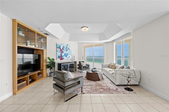 1170 Gulf Blvd Unit 2101, Clearwater Beach, FL 33767 - living room with a tray ceiling, baseboards, light tile patterned floors, and a textured ceiling