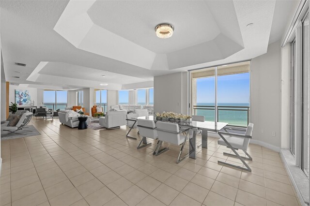 1170 Gulf Blvd Unit 2101, Clearwater Beach, FL 33767 - dining space with a tray ceiling, light tile patterned flooring, and a water view