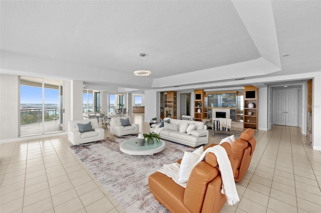 1170 Gulf Blvd Unit 2101, Clearwater Beach, FL 33767 - living area featuring light tile patterned floors, baseboards, a fireplace, and a textured ceiling