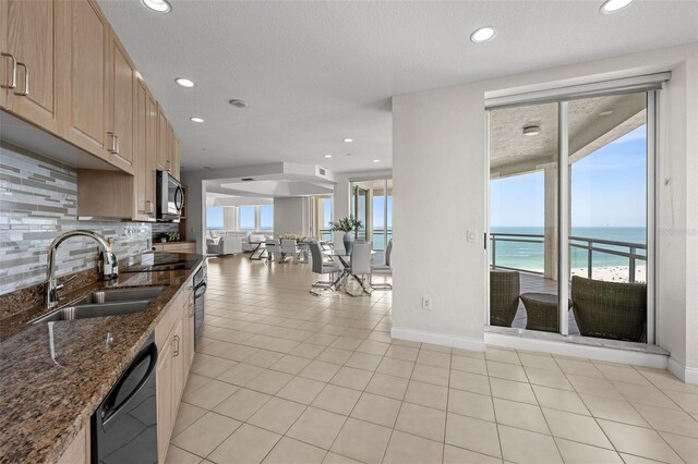 1170 Gulf Blvd Unit 2101, Clearwater Beach, FL 33767 - kitchen with a sink, dishwasher, stainless steel microwave, baseboards, and a water view