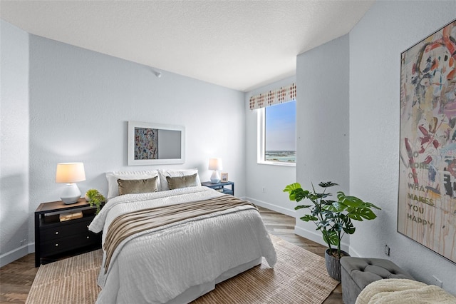 1170 Gulf Blvd Unit 2101, Clearwater Beach, FL 33767 - bedroom featuring baseboards, wood finished floors, and a textured wall