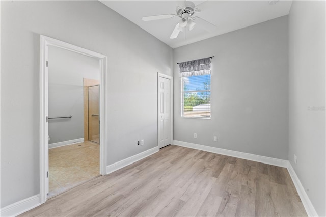 10517 Palm Cove Ave, Tampa, FL 33647 - unfurnished bedroom featuring baseboards, light wood-type flooring, and connected bathroom