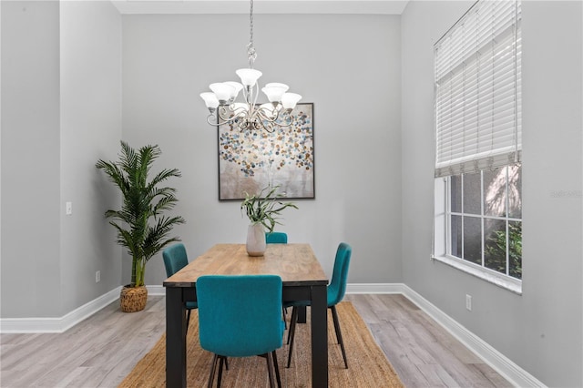 10517 Palm Cove Ave, Tampa, FL 33647 - dining area featuring baseboards, light wood-type flooring, and a chandelier