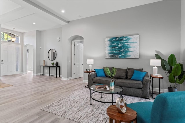 10517 Palm Cove Ave, Tampa, FL 33647 - living room featuring arched walkways, baseboards, wood finished floors, and beam ceiling