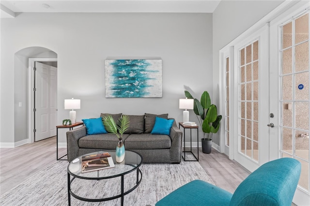 10517 Palm Cove Ave, Tampa, FL 33647 - living room featuring arched walkways, baseboards, and wood finished floors