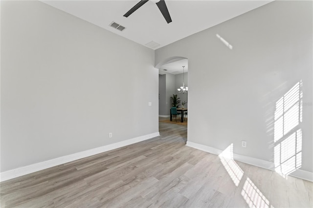 10517 Palm Cove Ave, Tampa, FL 33647 - empty room with arched walkways, visible vents, ceiling fan with notable chandelier, and light wood-type flooring
