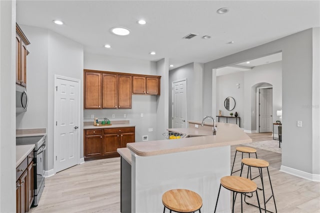 10517 Palm Cove Ave, Tampa, FL 33647 - kitchen with visible vents, a sink, arched walkways, stainless steel microwave, and electric stove