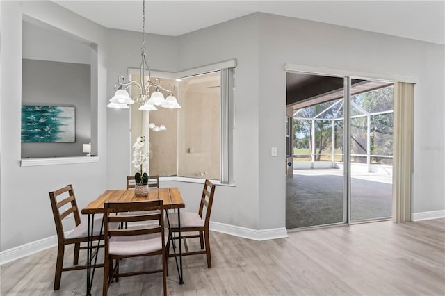 10517 Palm Cove Ave, Tampa, FL 33647 - dining area with baseboards, wood finished floors, and a notable chandelier