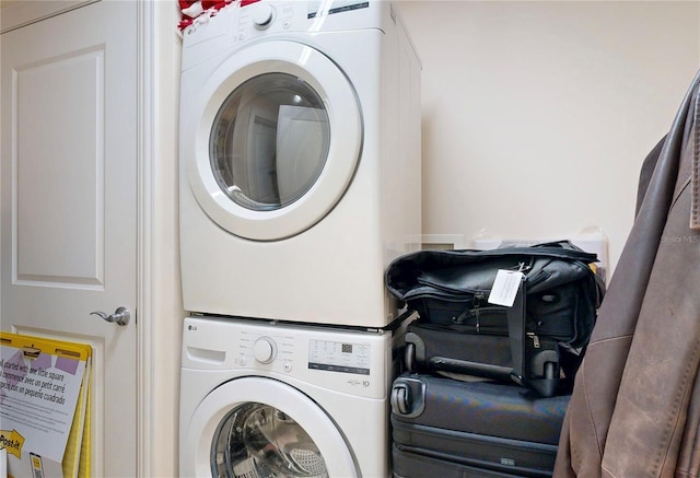 clothes washing area featuring stacked washing maching and dryer and laundry area