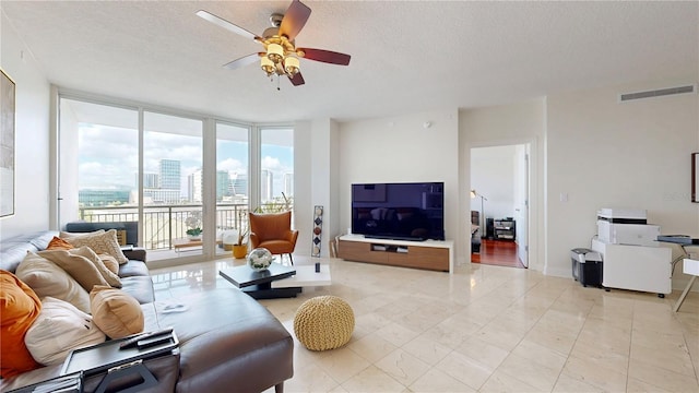 living area featuring a textured ceiling, ceiling fan, floor to ceiling windows, and visible vents