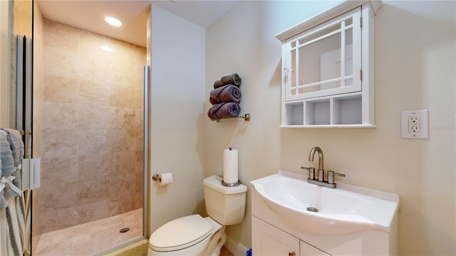 bathroom featuring toilet, a shower stall, and vanity
