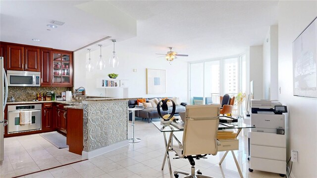 kitchen featuring decorative backsplash, a peninsula, dark brown cabinets, ceiling fan, and appliances with stainless steel finishes