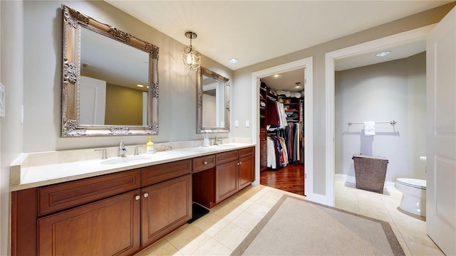 bathroom with double vanity, toilet, tile patterned floors, and a sink