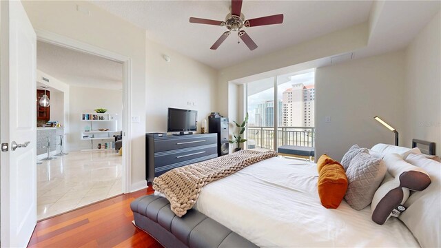 bedroom with baseboards, a ceiling fan, wood finished floors, and access to exterior