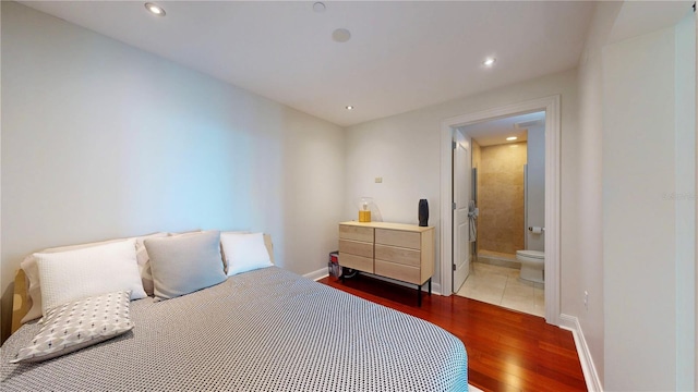bedroom featuring baseboards, recessed lighting, connected bathroom, and wood finished floors