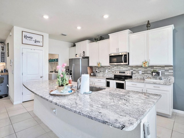 5464 Flint Hills Dr, Wimauma, FL 33598 - kitchen featuring visible vents, appliances with stainless steel finishes, a sink, baseboards, and white cabinets