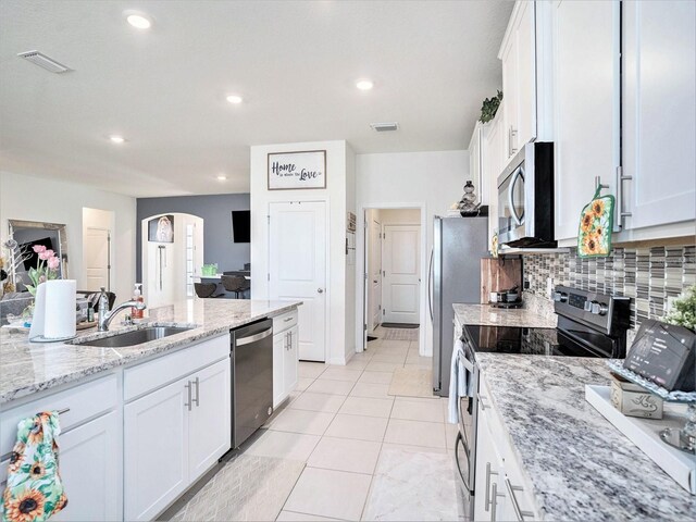 5464 Flint Hills Dr, Wimauma, FL 33598 - kitchen featuring visible vents, decorative backsplash, white cabinets, a sink, and stainless steel appliances