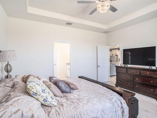 5464 Flint Hills Dr, Wimauma, FL 33598 - bedroom with visible vents, light carpet, stainless steel refrigerator with ice dispenser, a raised ceiling, and ensuite bath
