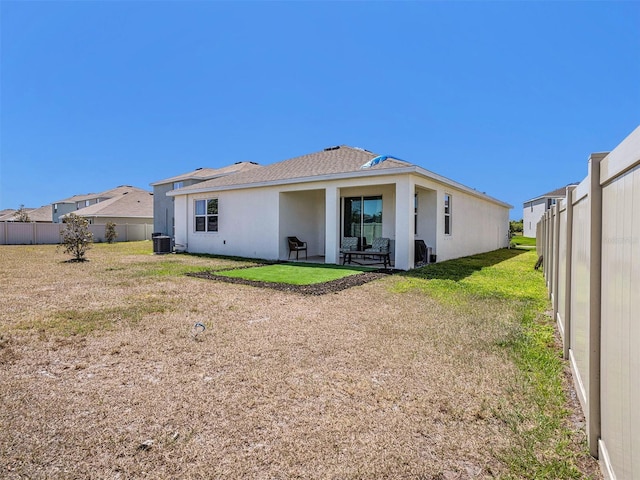 5464 Flint Hills Dr, Wimauma, FL 33598 - rear view of property featuring fence, a patio, stucco siding, and central AC