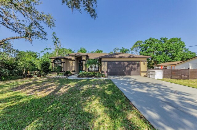 12923 Colony Rd, Hudson, FL 34669 - view of front of house with concrete driveway, an attached garage, a front yard, and stucco siding