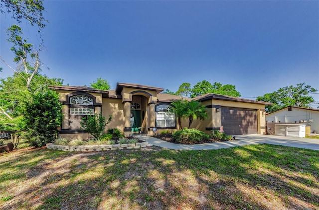 12923 Colony Rd, Hudson, FL 34669 - mediterranean / spanish-style home featuring stucco siding, an attached garage, driveway, and a front lawn