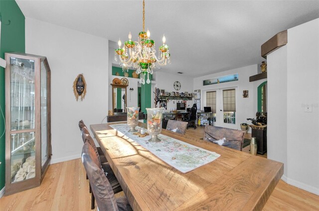 12923 Colony Rd, Hudson, FL 34669 - dining room with baseboards, light wood finished floors, a notable chandelier, and french doors