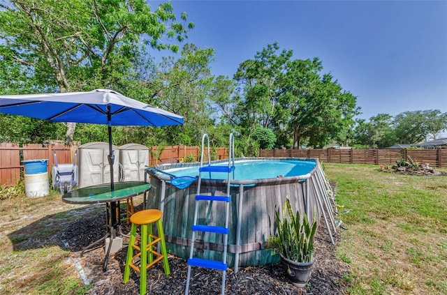 12923 Colony Rd, Hudson, FL 34669 - view of swimming pool featuring a fenced in pool, a fenced backyard, a yard, and a storage unit